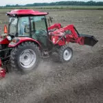 Mahindra 2670 compact utility tractor with cab plowing field.