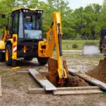JCB 3CX Compact Backhoe Loader digging a grave front view.