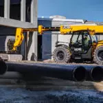 JCB 509-42 Telescopic Handler lifting bricks into building site.
