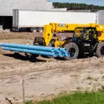 JCB 509-42 Telehandler carrying pipe materials.