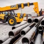 JCB 512-56 lifting metal pipes.