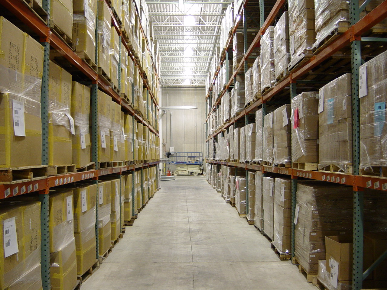 Warehouse aisle with racks storing boxes of product.