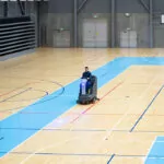 Advance SC4000 ride-on scrubber cleaning gymnasium floors.