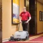 Advance Terra 28B walk-behind sweeper cleaning a carpet.