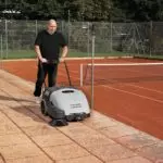 Advance Terra 28B walk-behind sweeper sweeping outdoor pathway.