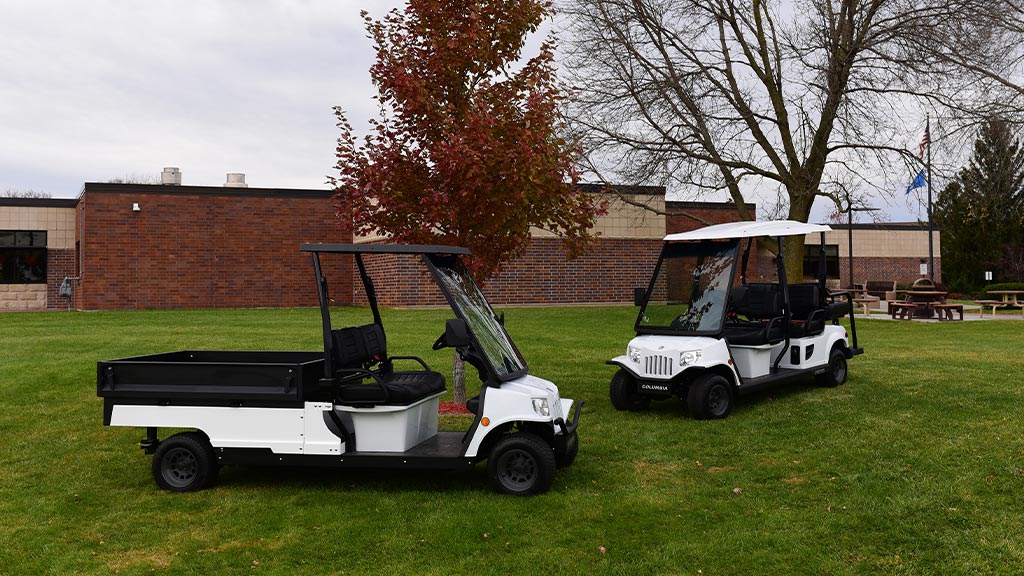 Columbia Journeyman utility vehicles parked on grass.