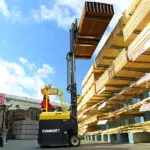 Combilift COMBI-CB Forklift lifting lumber in outdoor lumber yard.