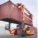 Combilift Combi-SC telescopic chain straddle carrier carrying and moving large containers.