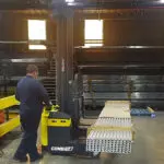 Combilift COMBI-WR4 Reach Stacker transporting metal in shop.