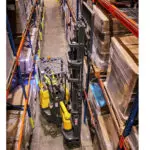 Combilift AC Electric Aisle Master lifting a pallet of goods off a warehouse pallet rack.