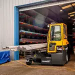 Combilift C-Series forklift truck carrying steel pipes.