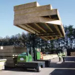 Combilift SL10000 Multi Directional Side Loader Forklift Truck transporting lumber on construction site.