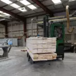 Combilift C Series C6000E electric forklift carrying lumber material.