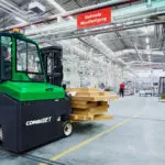 Combilift COMBI-CB8E Electric Forklift truck carrying wood in warehouse.
