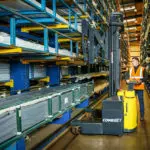 Combilift COMBI-WR4 Reach Stacker lifting material off shelf.