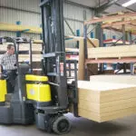Combilift AC Electric Aisle Master transporting lumber inside a warehouse.