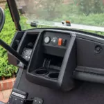 Cushman Shuttle 2+2 personnel carrier functional dash area with steering wheel, controls and cupholders.