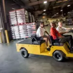 4-person Cushman Titan XD burden carrier driving into beverage warehouse.