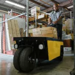Cushman Stock Chaser burden carrier with materials in a warehouse.