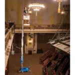 Employee in Genie AWP-25S Aerial Work Platform fixing a chandelier lighting fixture.