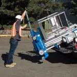 Genie AWP-30S aerial work platform being lifted into pickup truck bed.