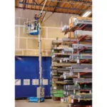 Worker raised to ceiling in bucket of Genie GR-20 vertical mast lift.