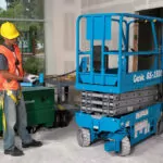Genie GS-1930 scissor lift lowered in construction doorway.