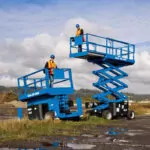 Genie GS-2269 and GS-4069 scissor lifts on small dirt hill.