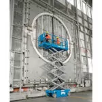 Workers repairing side of a building in Genie GS-3246 scissor lift.