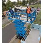 Genie GS-4069 DC aerial scissor lift with workers in bucket.