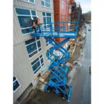 Workers raised in bucket of Genie GS-4390 scissor lift.