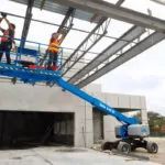 Genie S-40 HF and S-45 HF Telescopic Boom Lift lifting two workers up to build a new roof.