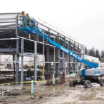 Genie S-45 XC telescopic boom lift lifting workers to build a roof.