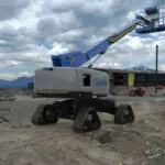 Genie S-45 XC TraX telescopic boom lift on dirt terrain.