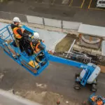 Genie S-65 XC telescopic boom lift lifting workers.