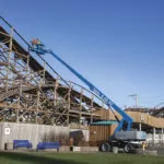 Workers in Genie S-65 XC boom lift bucket, working on a rollercoaster.
