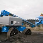 Genie S-65 TraX boom lift on rough terrain.