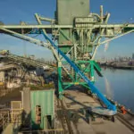 Genie SX-150 aerial boom lift raising workers in the bucket.