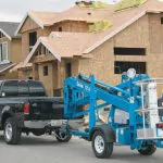 Genie TZ-34/20 trailer-mounted boom lift being pulled behind a truck.