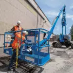 Operator hooking himself to Genie Z-62/40 articulating boom lift basket.