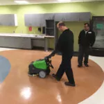 IPC Eagle CT15 walk-behind scrubber cleaning room floors.