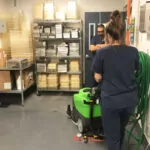 Girl cleaning small shop with IPC Eagle CT45 walk-behind scrubber.