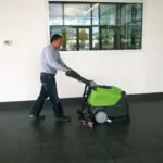 IPC Eagle CT45 walk-behind scrubber cleaning open office space floor.