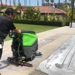Man cleaning sidewalks outside with IPC Eagle CT71 walk-behind scrubber.