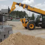 JCB 512-56 Telehandler placing pallet of bricks on construction platform.