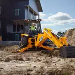 JCB 3CX Backhoe Loader digging on working construction site.