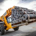 JCB 512-56 carrying pallet of rolled material.