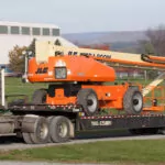 JLG 1500SJ Ultra Series telescopic boom lift traveling on trailer.