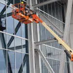 JLG 1500SJ boom lift raising workers to clean windows.