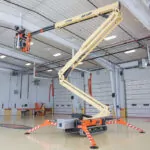 JLG X770AJ boom lift extended inside garage.